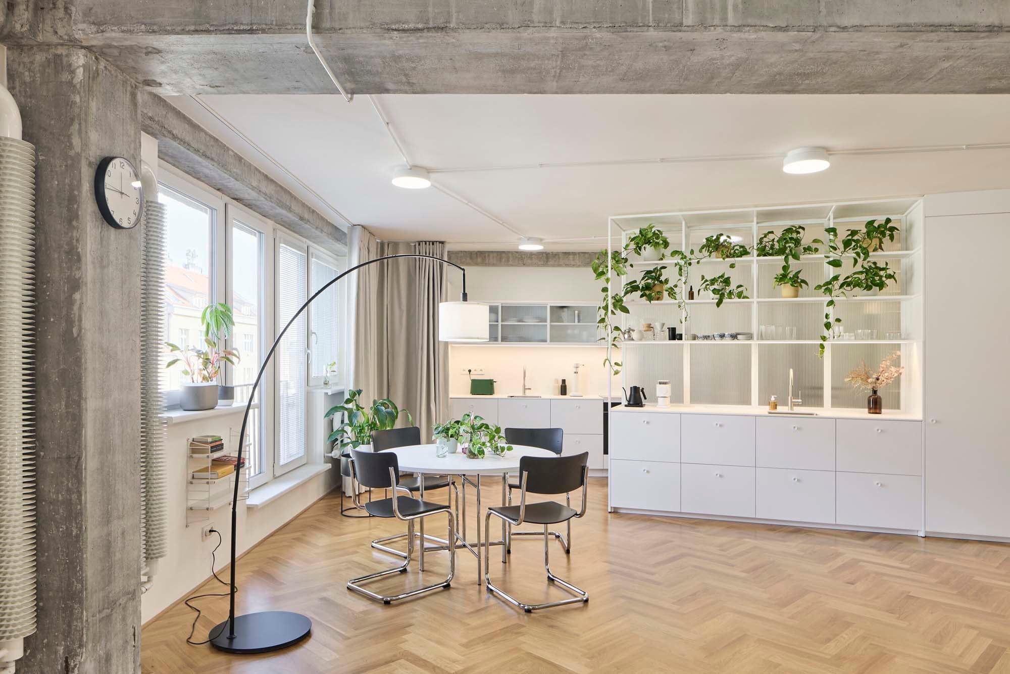 Fast alle Innenwände wurden entfernt. Die Wohnung organisiert sich nun um einen zentralen, weißen Einbaukörper herum. Die kleine Küchenzeile im Wohnbereich funktioniert eher wie ein Café als wie eine klassische Kochstation. Die voll ausgestattete Hauptküche liegt im hinteren Bereich des Apartments und kann per Vorhang abgetrennt werden.