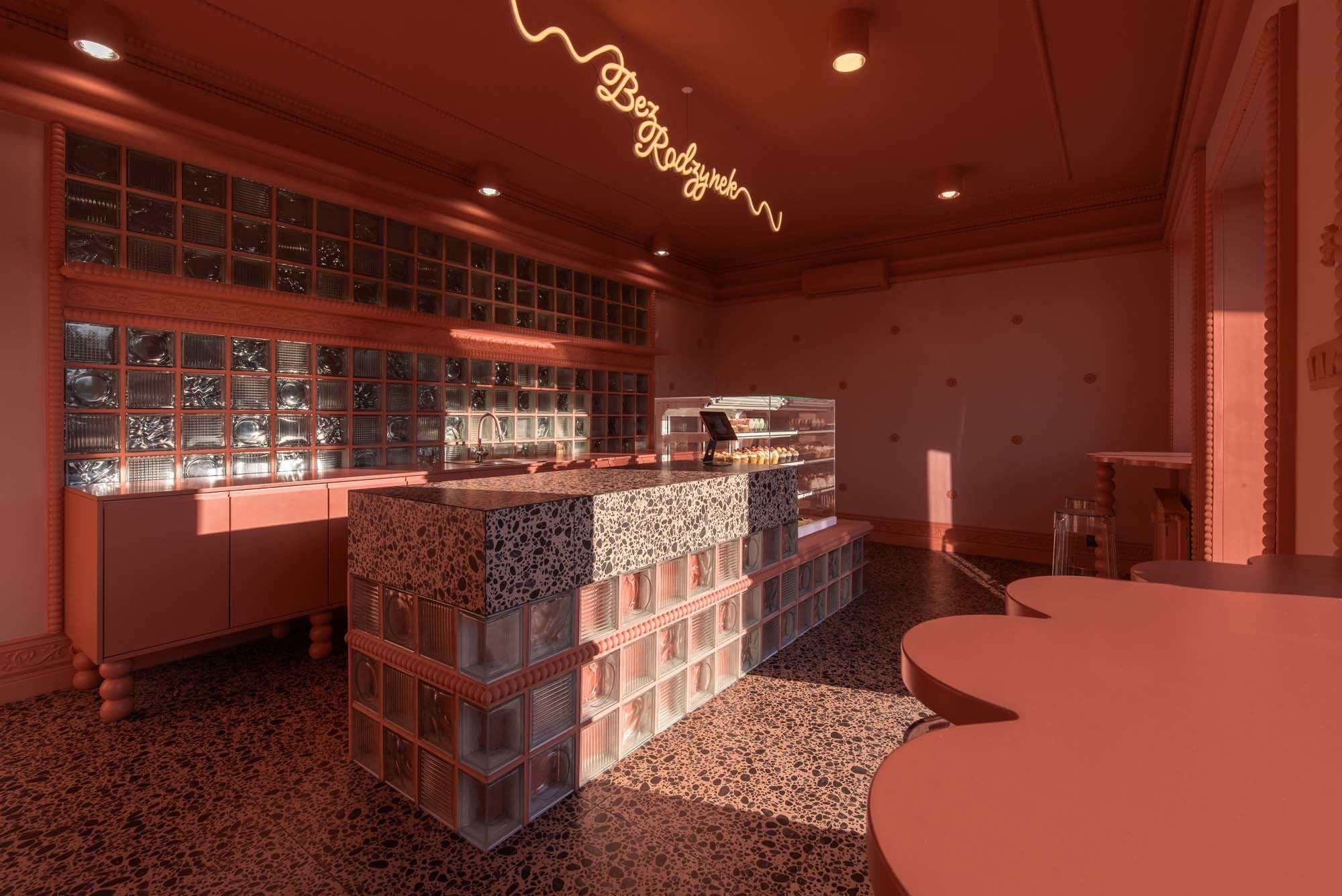 Zentraler Fokus: Der Tresen mit integrierter Kuchenvitrine strukturiert den Raum und lenkt den Blick unmittelbar auf die Auslage.