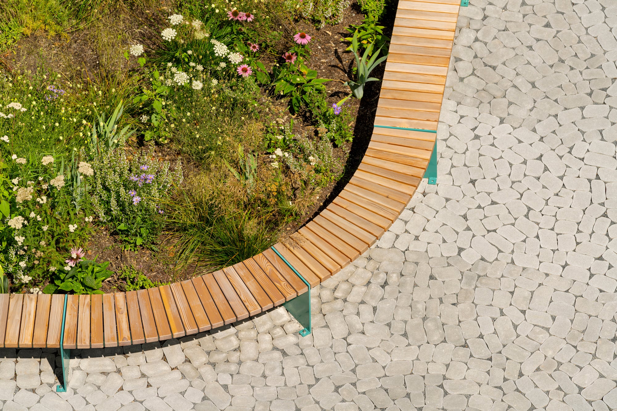 Die organische Form der Steine passt zu den geschwungenen Beeten.