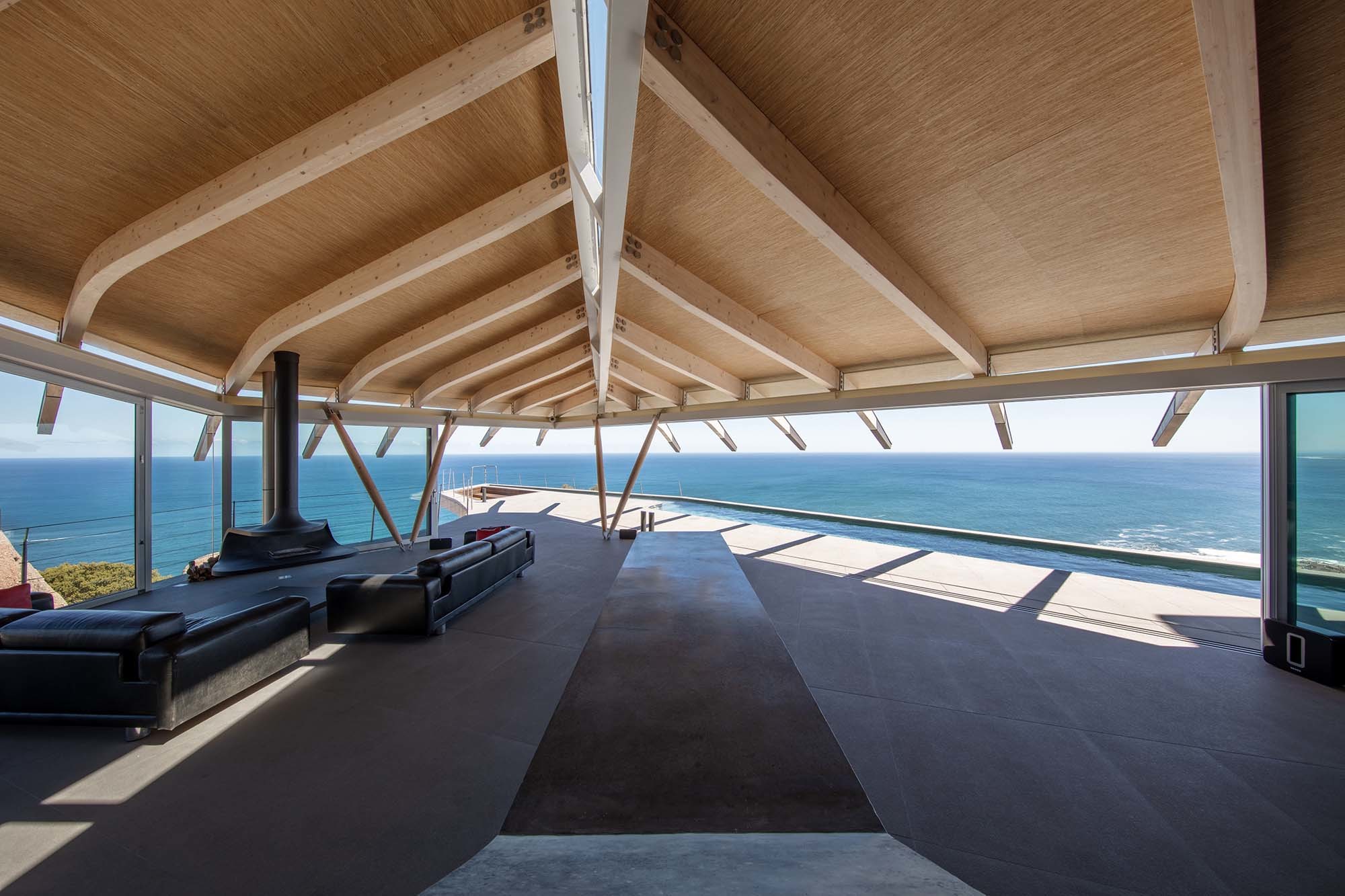 Das weit auskragende Dach wirkt wie ein geblähtes Segel und rahmt den Blick auf Meer und Horizont.