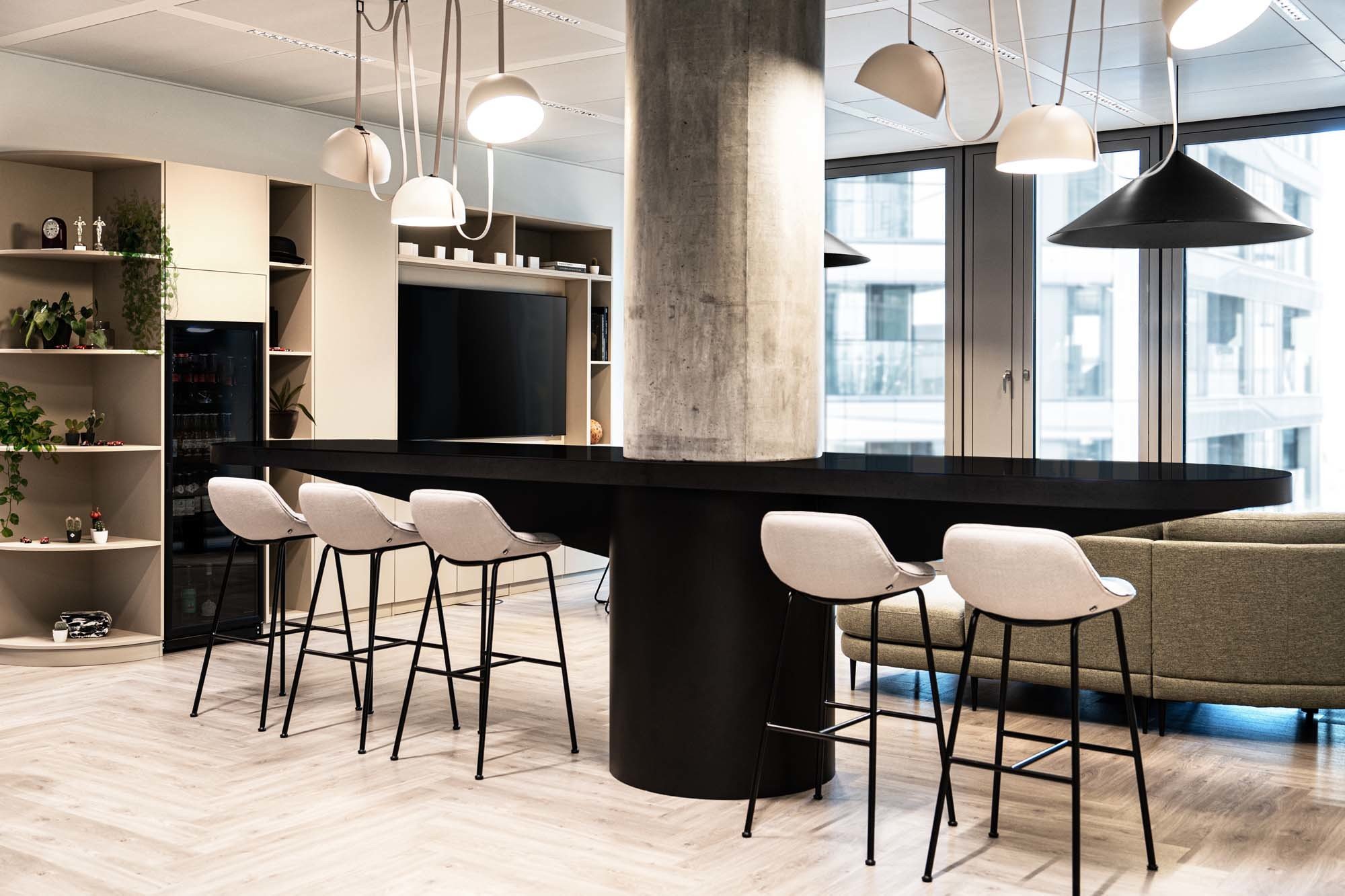 In der Lounge verbinden warme Materialien und klare Linien den Komfort eines Rückzugsorts mit der Offenheit des Büroensembles.