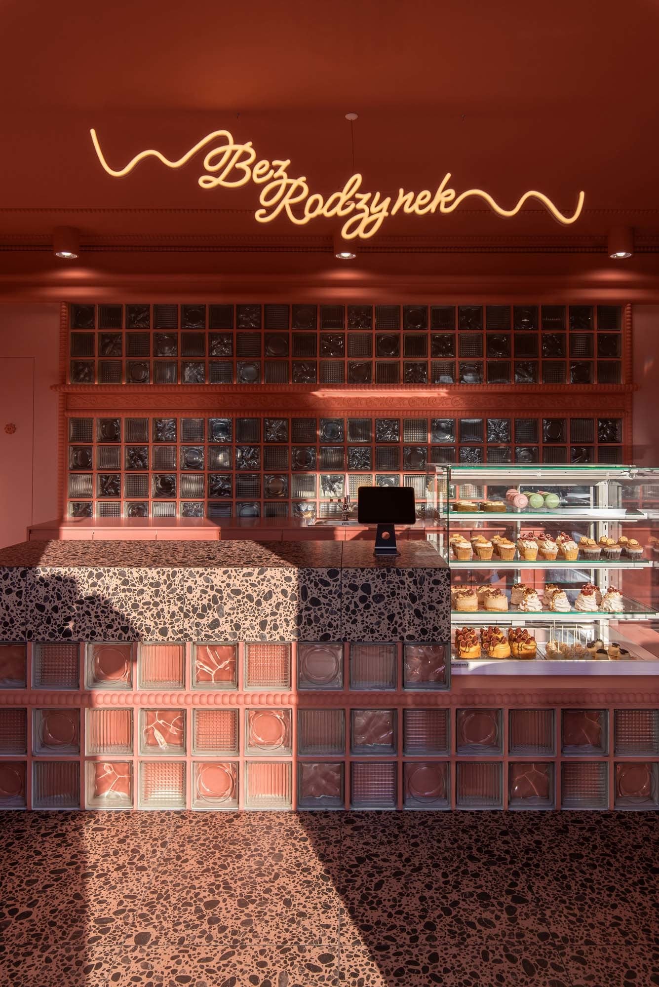 Boden und Arbeitsfläche aus gesprenkeltem Terrazzo erinnern an zerbröselte Schokolade und sind ein bewusster Gegenpol zur ruhigen Farbigkeit.