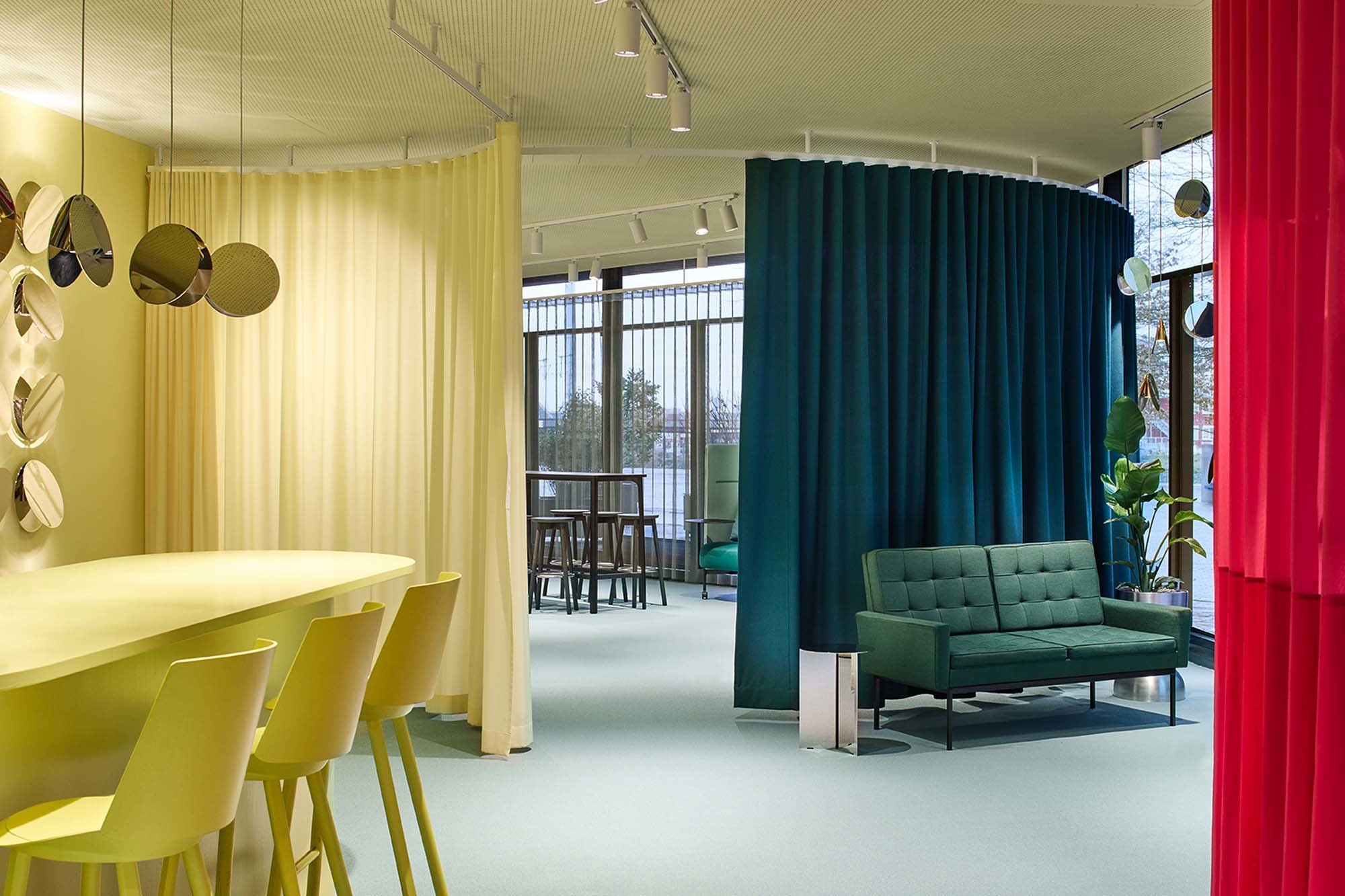 Ikonische Möbel im Einsatz – Originalstücke wie das grüne Knoll-Sofa und Pantons Spiral-Leuchten prägen das Ambiente.