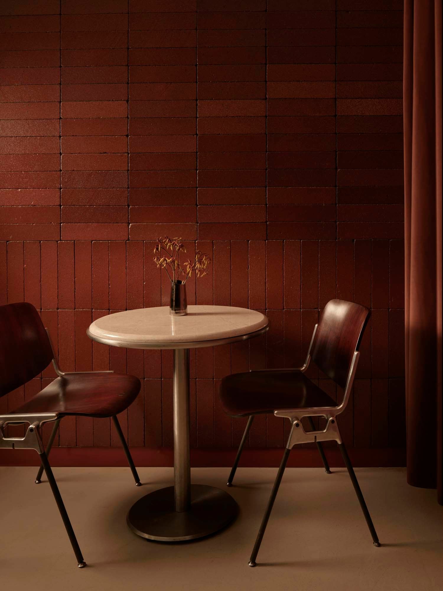 Die Holzstühle DSC 106 wurden von Giancarlo Piretti 1965 für Anonima Castelli entworfen. Die dunkel gebeizte Version ergänzt hier die Ästhetik der eleganten Handschrift der Interiordesiger*innen.