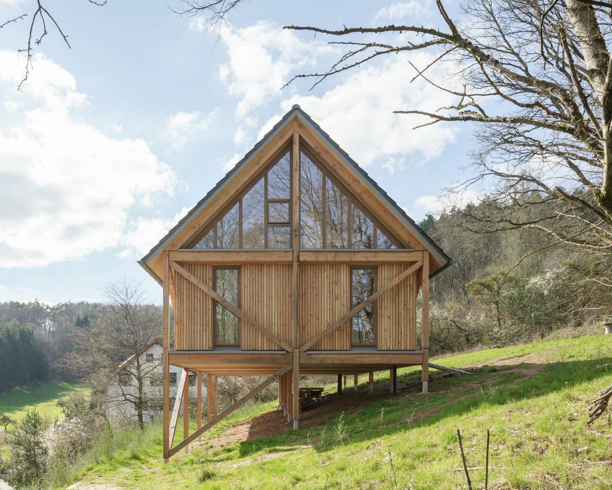Auf einem Hanggrundstück im Pfälzerwald baute dury et hambsch architektur ein Holzhaus für zwei kunstaffine Bauherr*innen.