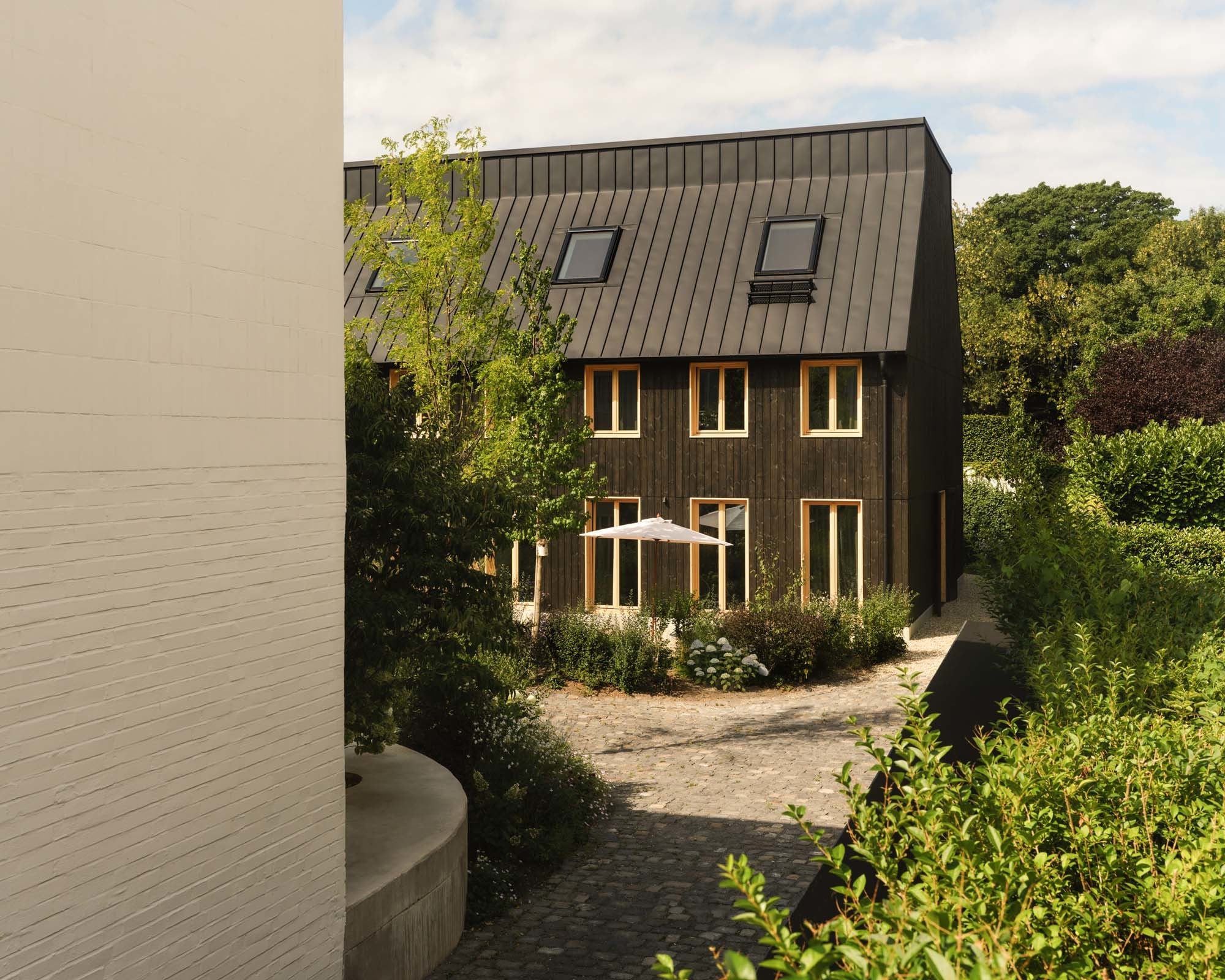 Als Holzbau bezieht sich das Hofhaus auf die Typologie einer Scheune.