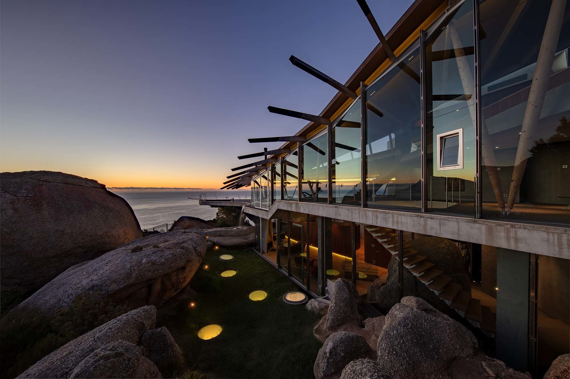 Großformatige Glasflächen und präzise Stahlverbindungen zeichnen die expressive Form des Hauses nach.