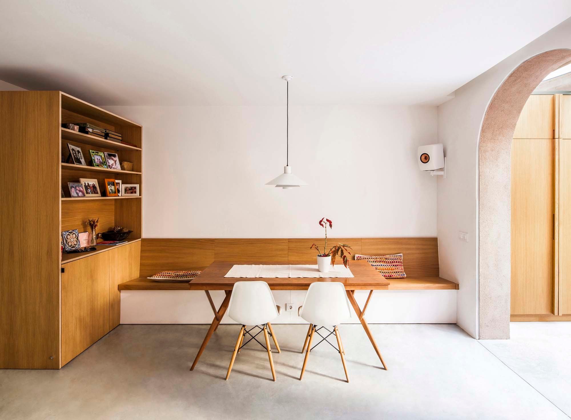 Holzoberflächen prägen die warme, wohnliche Atmosphäre und kontrastieren mit kühlen Farbtönen und glatten Glasflächen.