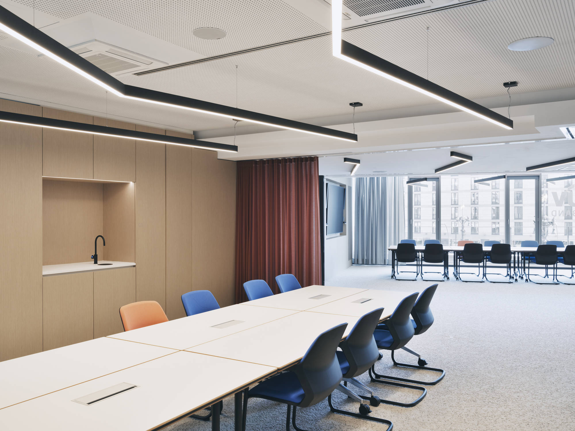 Verbindung mit System: Die mit mobilen Timetable-Tischen und stapelbaren Metrik-Sesseln ausgestatteten Konferenzräume K1 und K2 können durch eine mobile Glaswand und Vorhänge geöffnet und zu einem großen Gremienraum verbunden werden.