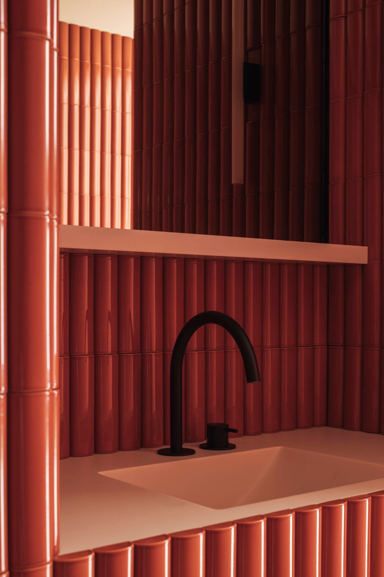 Zahnarztpraxis von Dries De Malsche in Belgien: Knallorangene Fliesen treten als korbbogenförmige Halbröhren aus der Wand hervor und verleihen den Oberflächen eine ausgeprägte räumliche Tiefe.