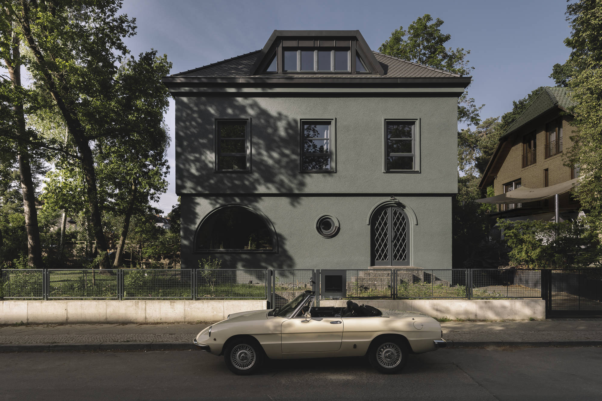 Atelier ST baute in Tauts Berliner Eichkamp-Siedlung ein Haus, das sich tarnt und zugleich zeigt. Außen ist es grün verputzt, innen offenbart sich ein warmer Holzraum.