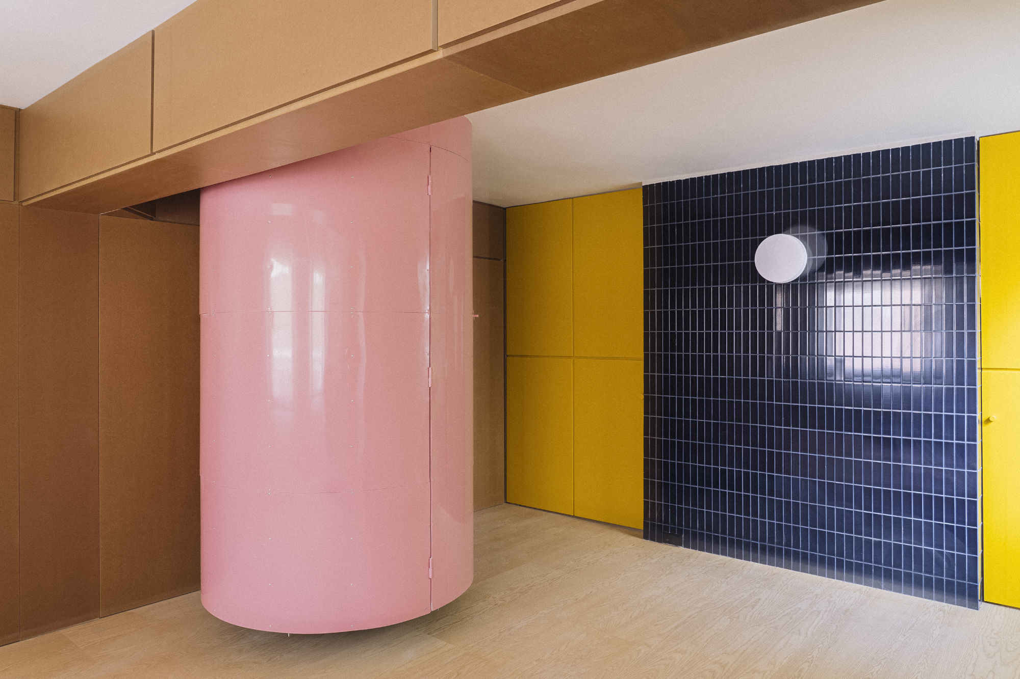 Durch die rosafarbene Röhre des Madrider Apartments von Burr Studio geht es in die Dachkammer. Das gelbe Regal führt zu einem Rückzugsort mit Studienzimmer und Schlafgemach.