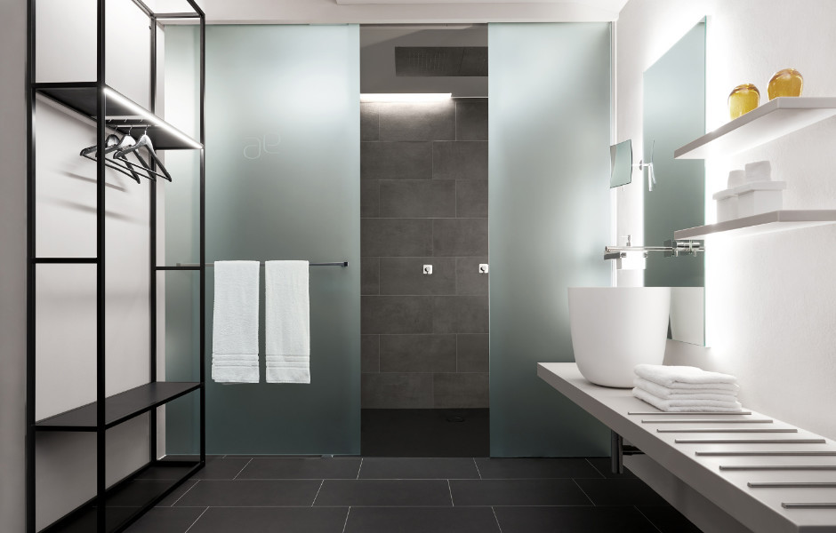 Sliding doors made of satin-finished glass separate shower and WC niche and provide intimacy.