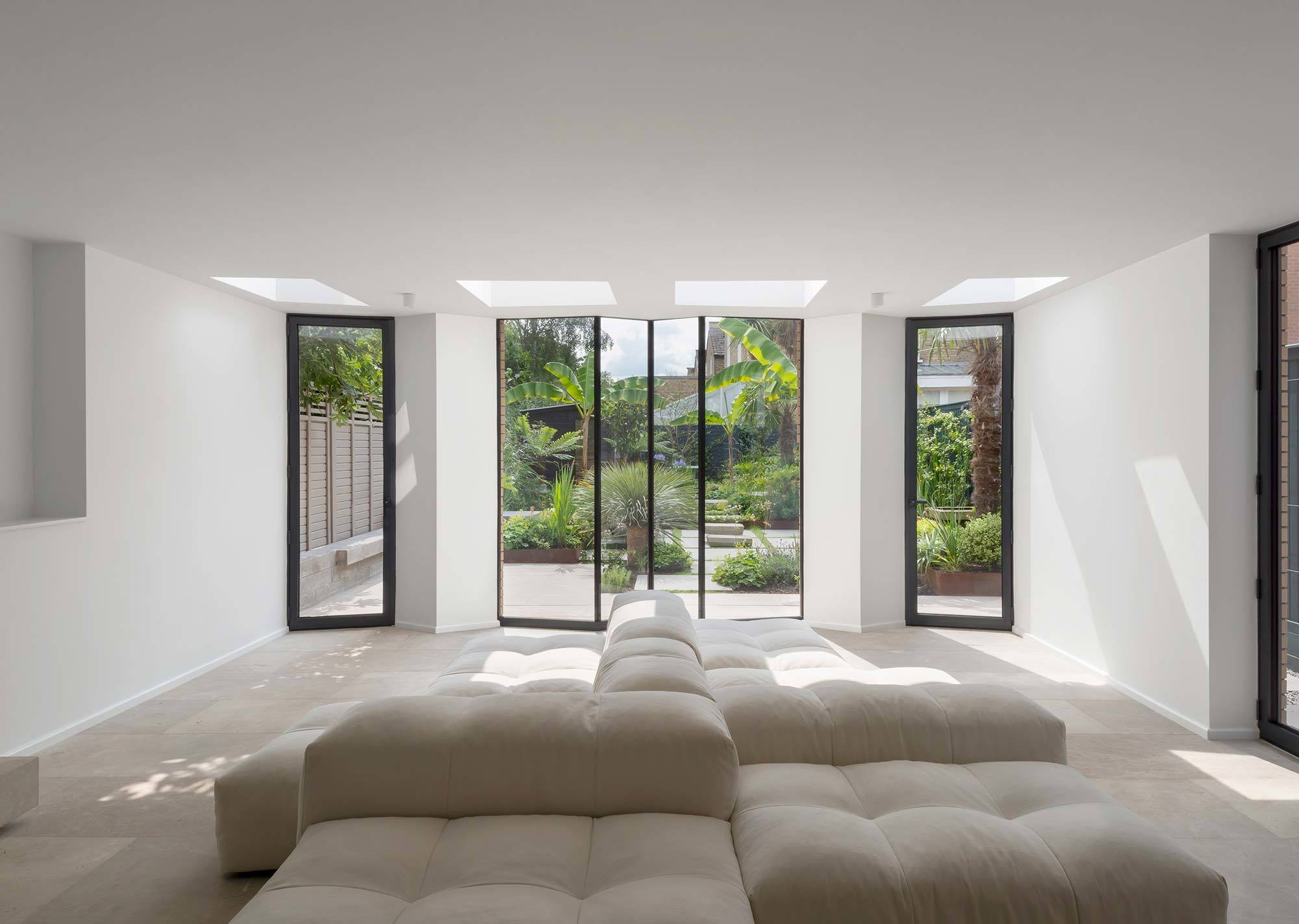 Die große Glasfront und die Oberlichter lassen viel Licht ins Wohnzimmer.