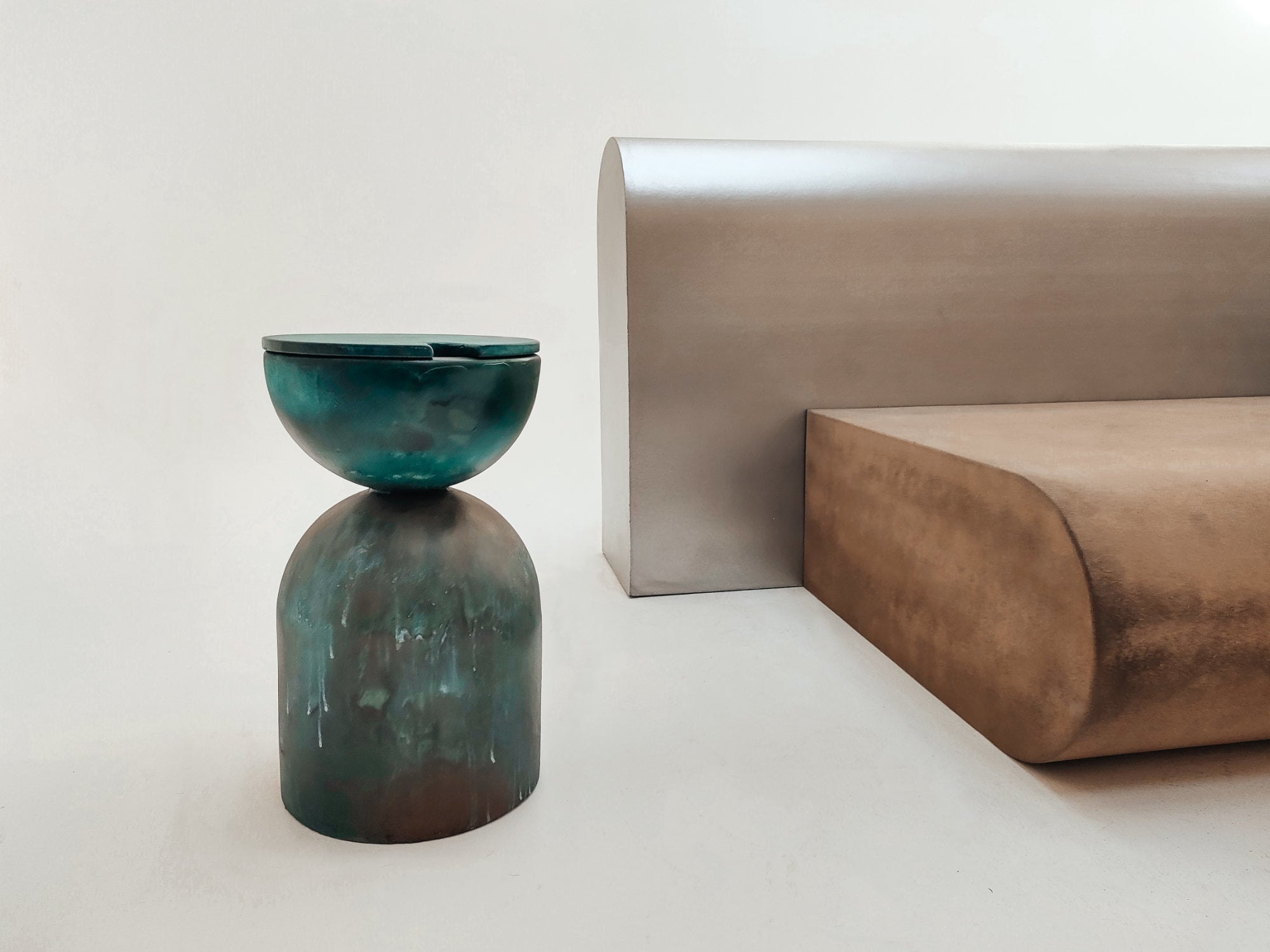 Edelmetall trifft Reststoff: Kupferbeschichtete Sitzflächen ergänzen die matte Struktur der Recyclingmodule – sichtbar handwerklich und robust zugleich.