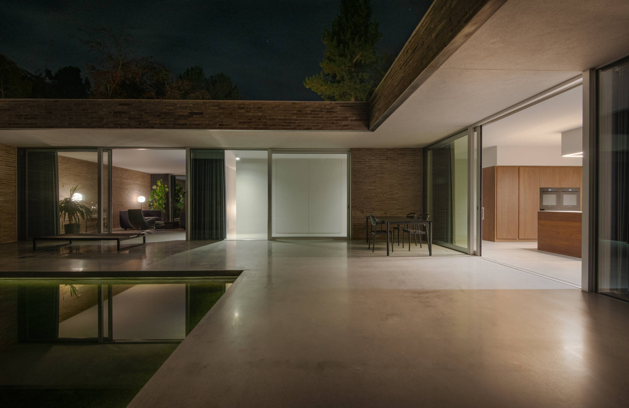 Das Wohnhaus House at King's Cairn von Daniel Bär Architect gruppiert sich um einen geschützten Innenhof mit flachem Wasserbecken.