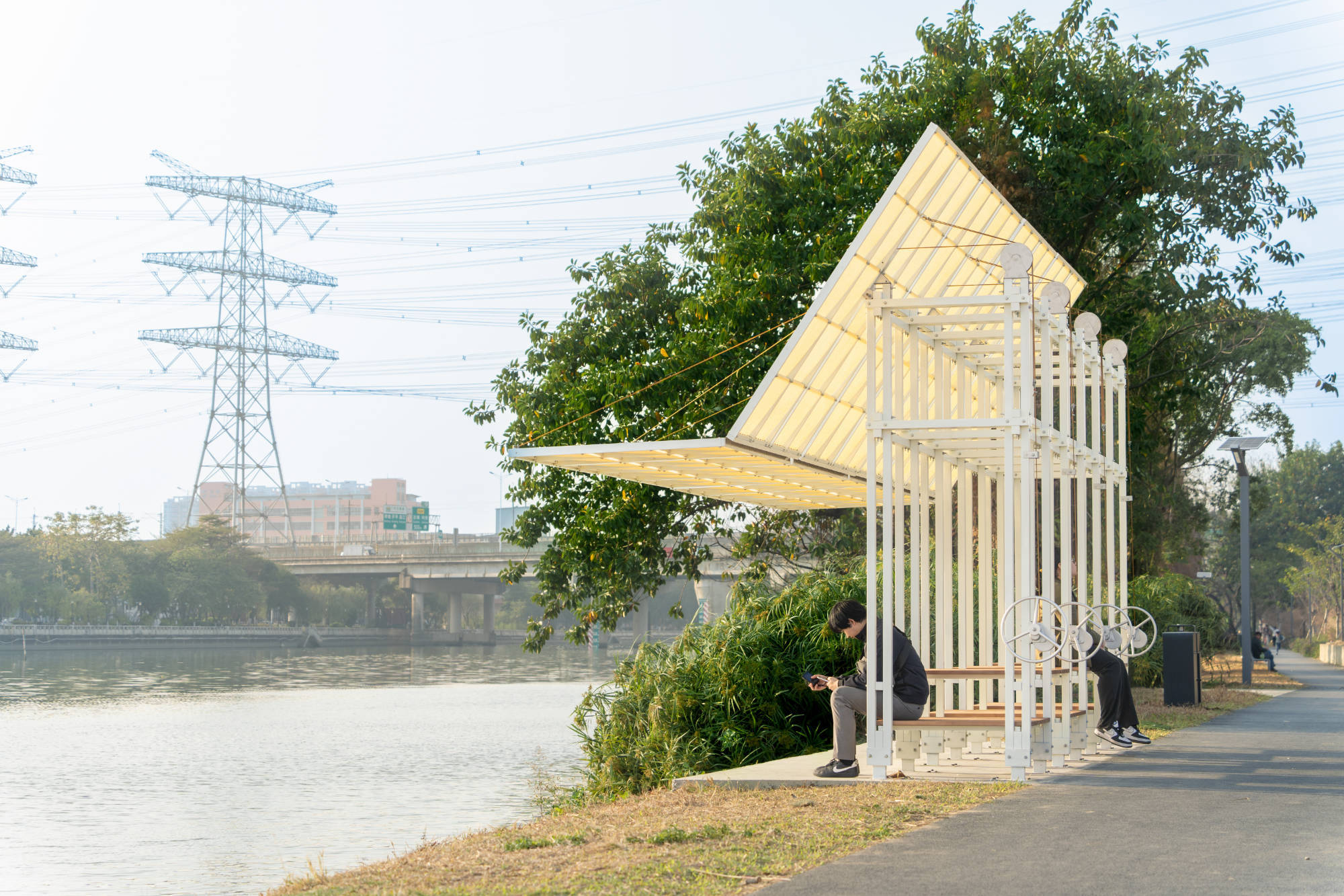 Sonnenschutz schafft Schatten – und damit Aufenthaltsqualität. Im Bild: Flipmod, Standort Flussufer, Foshan, Guangdong, China, 2026 – Ambit Narrative Design, manuell verstellbares modulares Verschattungssystem