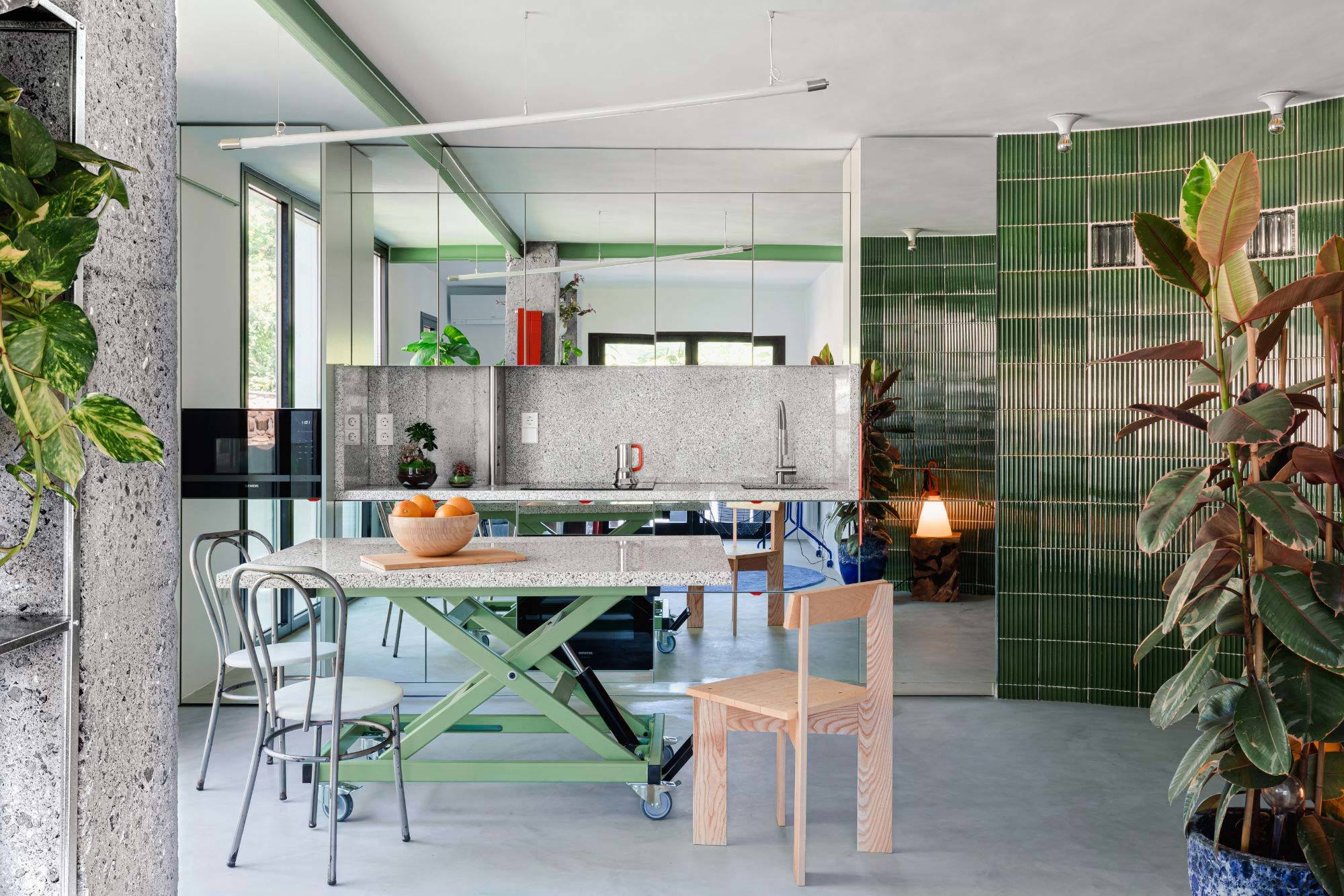 Für die Küche der Wohnung The Unplanned Domestic Prototype in San Sebastián kombinierte Ismael Medina Manzano wiederverwendete Granitplatten mit gespiegelten Schränken und grünen Fliesen.