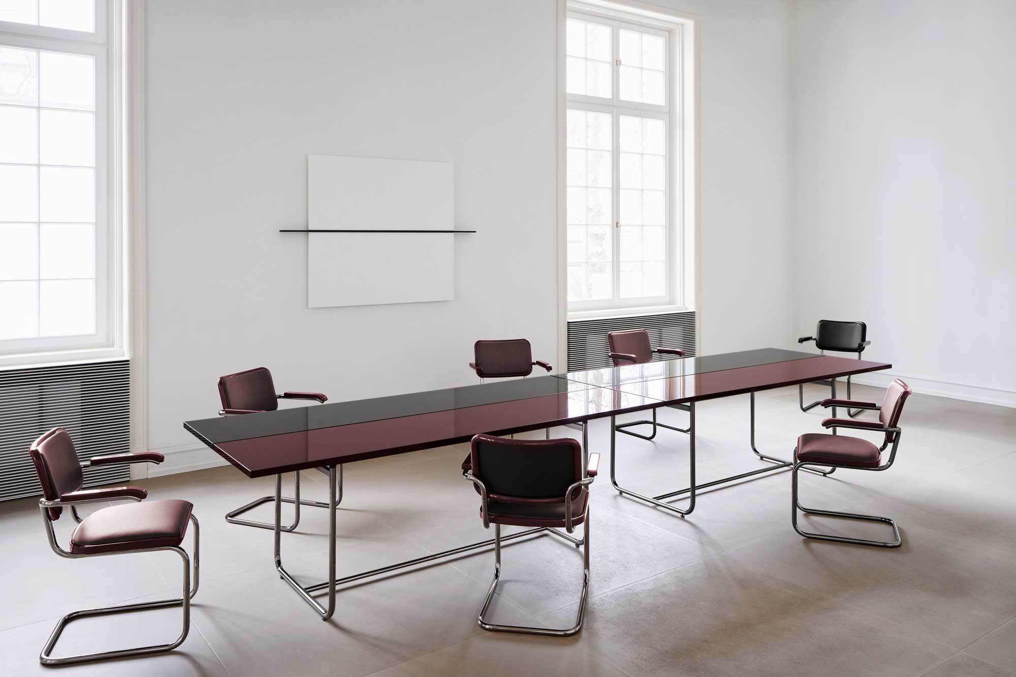 Die Tischplatte des S 1070 besteht aus zwei längs geteilten Elementen, die eine feine Fuge trennt. Das Design erlaubt es, unterschiedliche Oberflächen miteinander zu kombinieren, wie die Variante Serious mit den Farben Graphite Black und Graphite Ruby Red.
