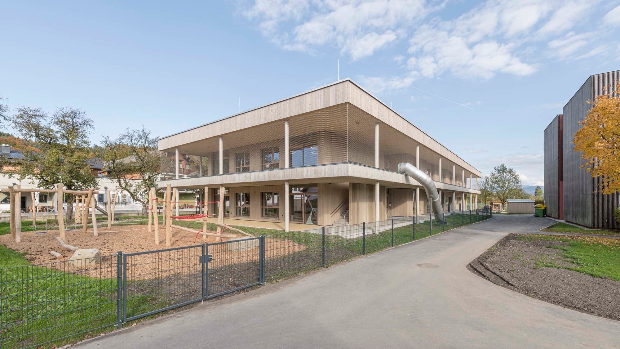 Der zweigeschossige Holzhybridbau von dem Büro architekten schoenberger fügt sich mit seiner holzverkleideten Fassade in die naturnahe Umgebung ein.