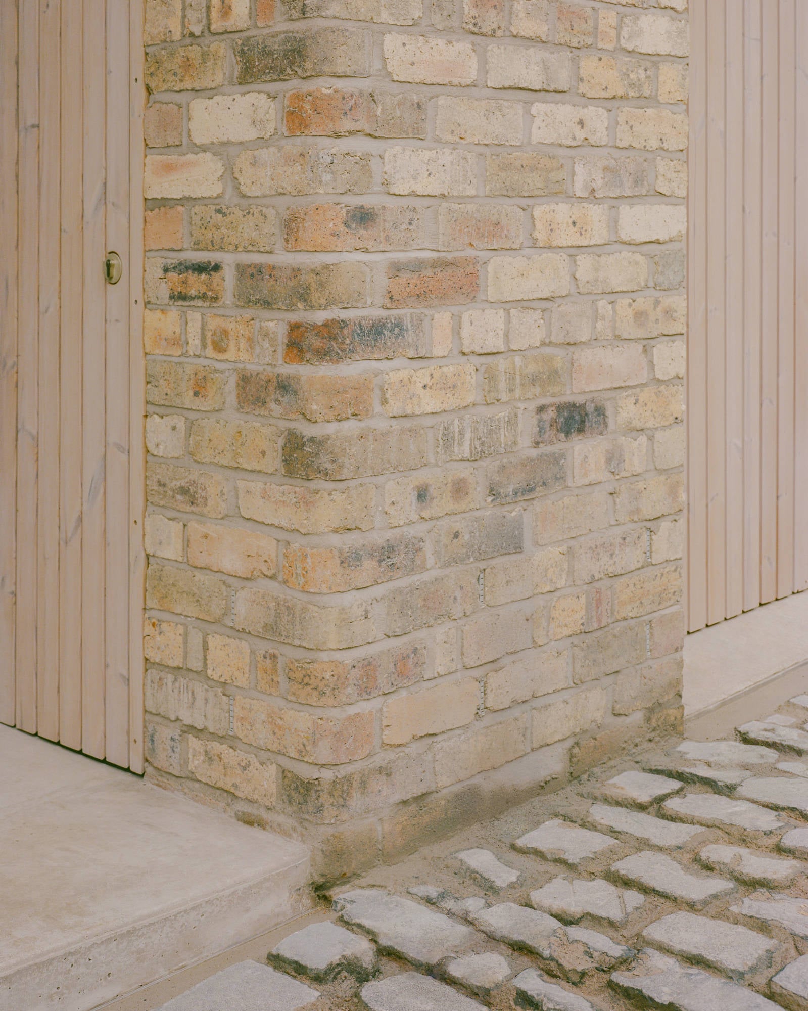 An den Gebäudekanten setzen abgerundete Bullnose-Ziegel ein feines handwerkliches Zeichen – ein Zitat aus der historischen Mews-Bauweise.