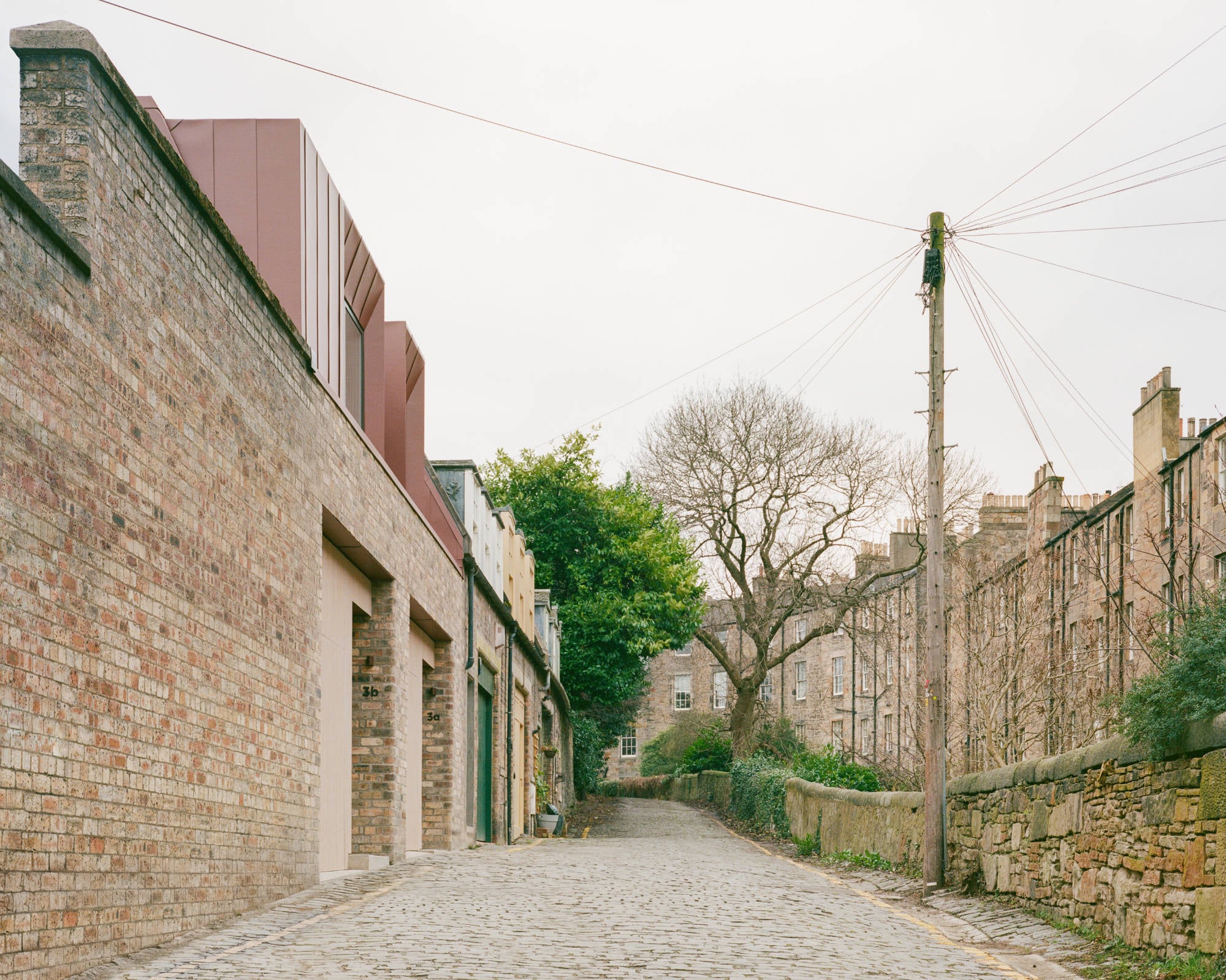 Der Neubau behauptet sich selbstbewusst in der gewachsenen Mews-Zeile, ohne den Maßstab der Nachbarbebauung zu sprengen.