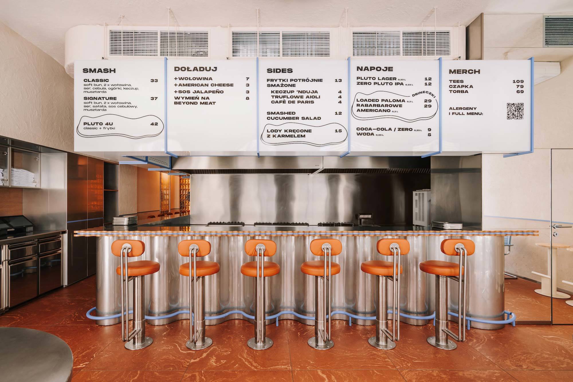 Pluto Burger, Breslau: Karamelltöne und warmes Licht zitieren die Zubereitung der Smash Burger und prägen das Interior von Znamy Się.