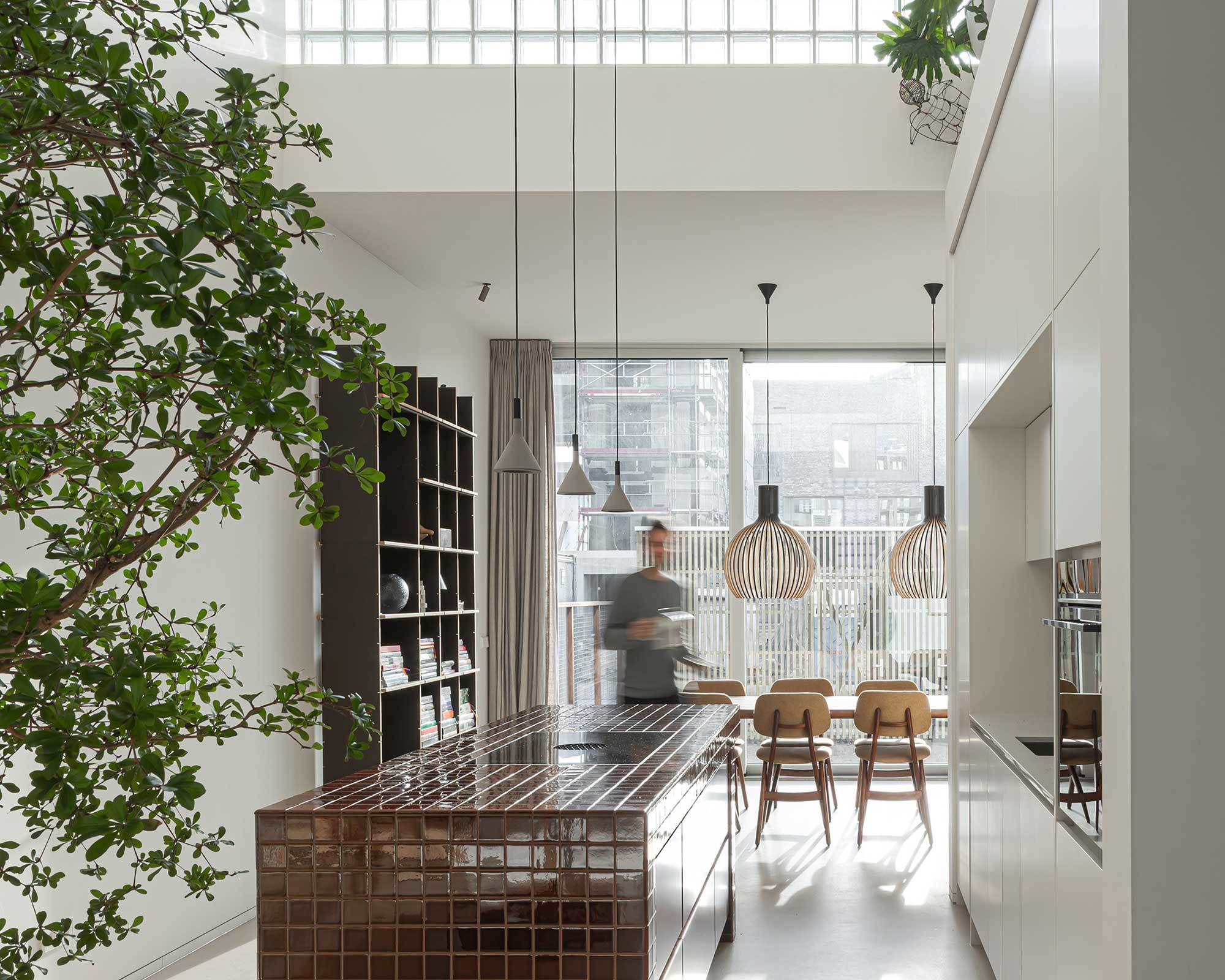 Mit dreidimensional verzahnten Funktionsblöcken und einer Fassade aus Glas und Gittern ist der Wohnturm von Studioninedots ein ungewöhnliches Zuhause für eine Amsterdamer Familie.