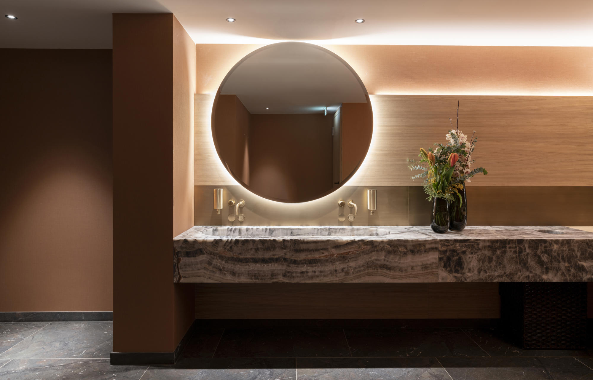 Parkhotel Egerner Höfe, Rottach-Egern: Die Sanitärräume sind mit VOLA-Armaturen in gebürstetem Gold ausgestattet, darunter berührungslose Waschtischarmaturen (Modelle 4921+T10 und HV1E/150) sowie die Betätigungsplatte A85.