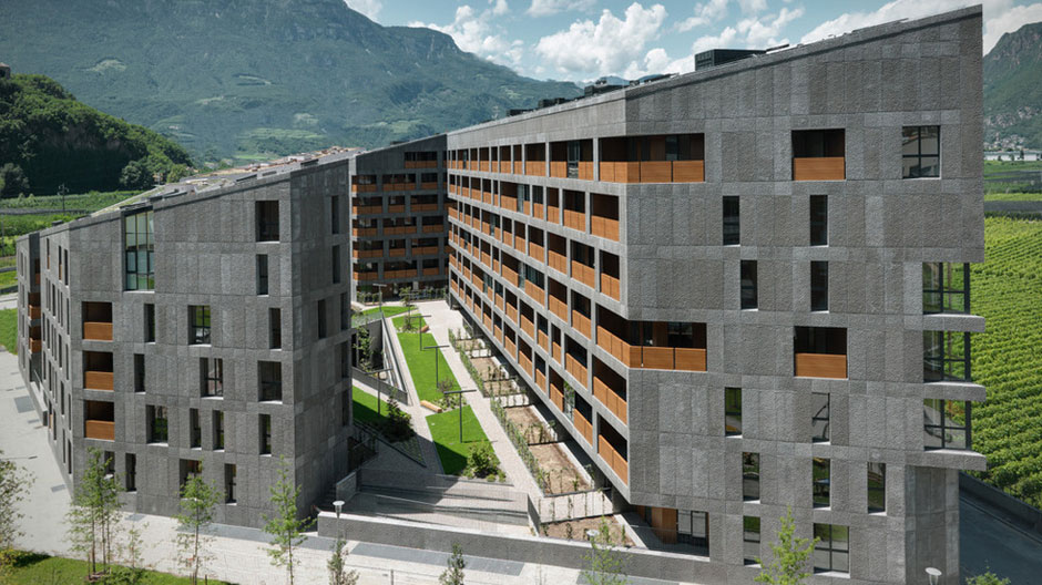 Ein sozialer Wohnungsbau in Bozen stemmt sich selbstbewusst der alpinen Kulisse entgegen.