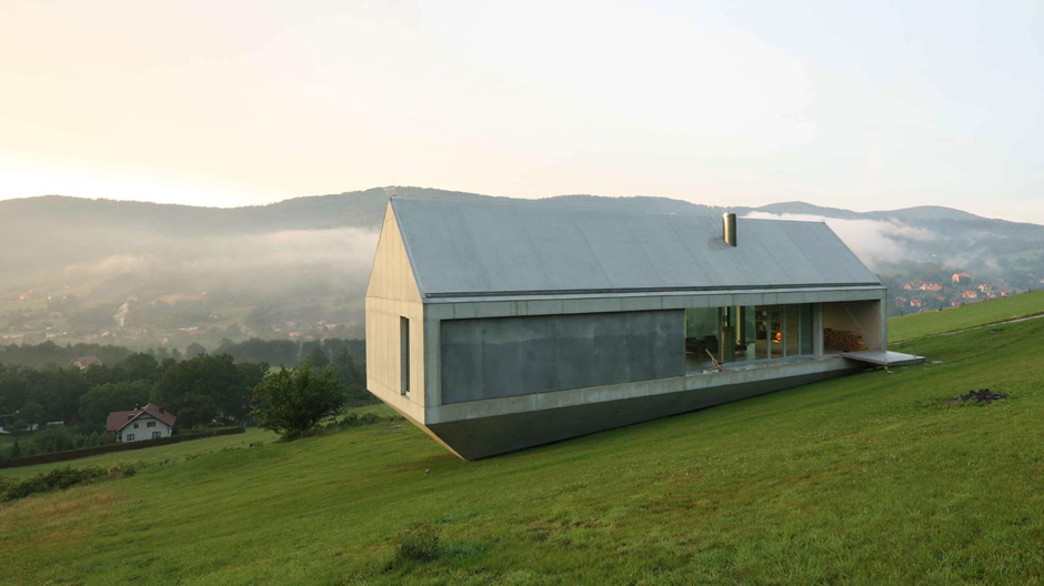 Schwebende Beton-Glas-Skulptur am Hang.