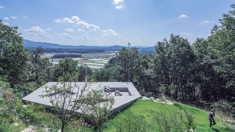 Bündig im Hang: Das Wohnhaus einer Künstlergemeinschaft in Südkorea ist in das Erdreich eines Berges eingegraben.