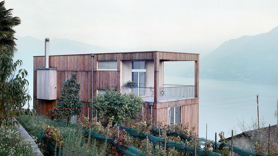 Mitten in einem Tessiner Weinberg: ein einfacher Holzkubus mit Postkartenaussicht.