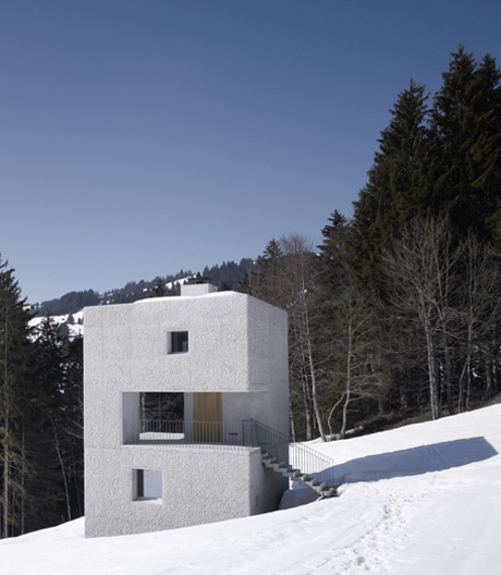 Ein Betonmonolith als Schutzhütte, in dessen Mitte sich ein halbes Leergeschoss schneidet.