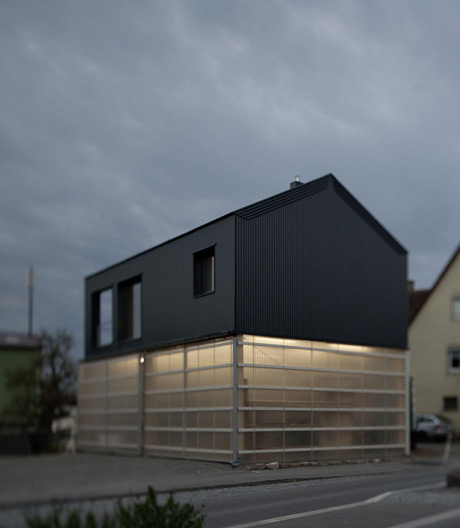 Tagsüber eine lichtdurchflutete Werkstatt, nachts ein leuchtender Kubus: Haus Unimog.