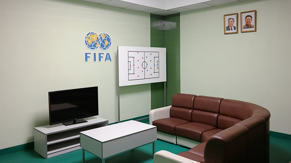 Oliver Wainwright zeigt ein idealisiertes Bild von Macht und Ordnung, in dem pastellfarbene Bauten scheinbar von Prosperität und Wohlstand zeugen.